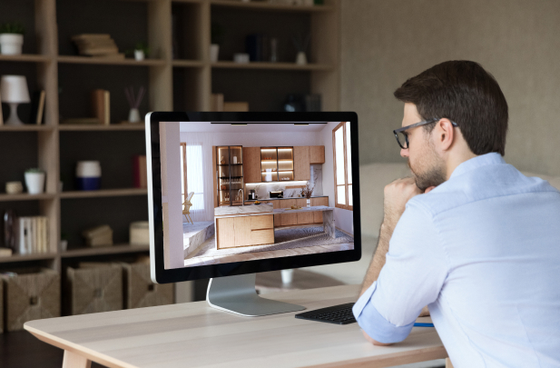 Man viewing a 3D kitchen design rendering on a desktop monitor as part of CabinetCorp’s virtual kitchen design services
