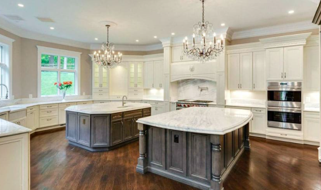 Antique white upper cabinets with a gray wood-grain island 