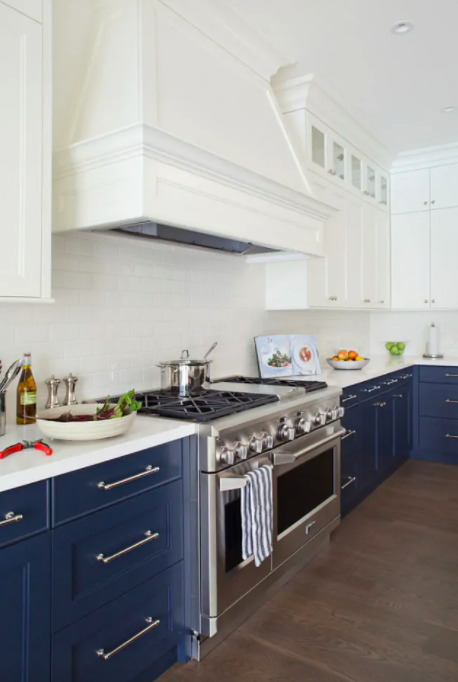 White Shaker-style upper wall cabinets with navy base cabinets 