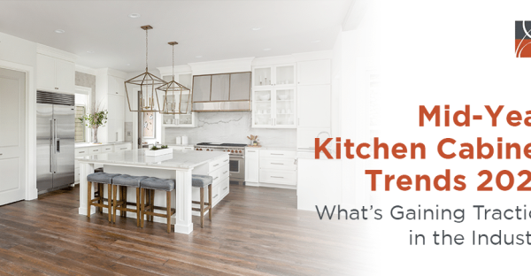 Bright modern kitchen featuring white cabinets, island seating, and warm wood flooring